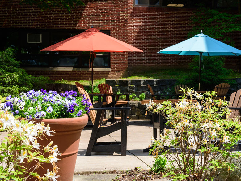 Tables with umbrellas and flowers in a courtyard.