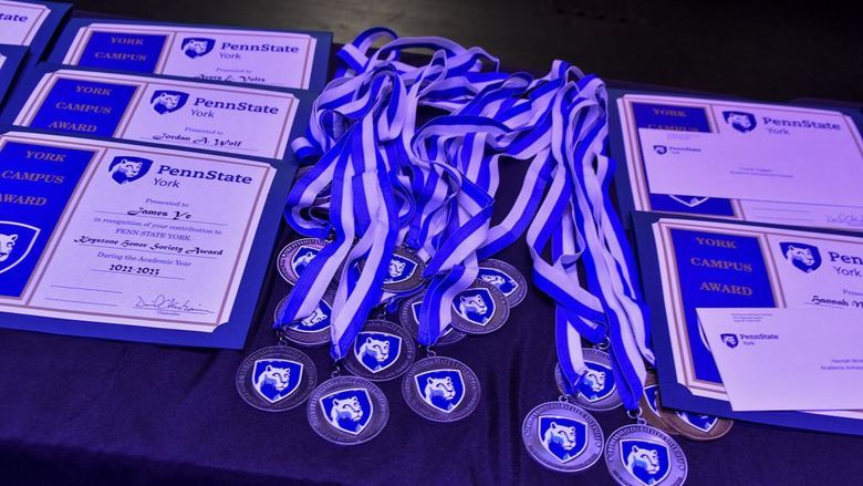Certificates and award medallions on a table