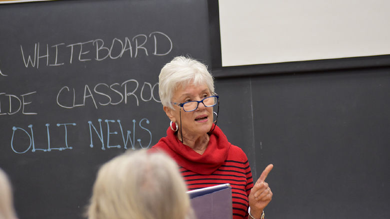 Older woman speaking to a class.
