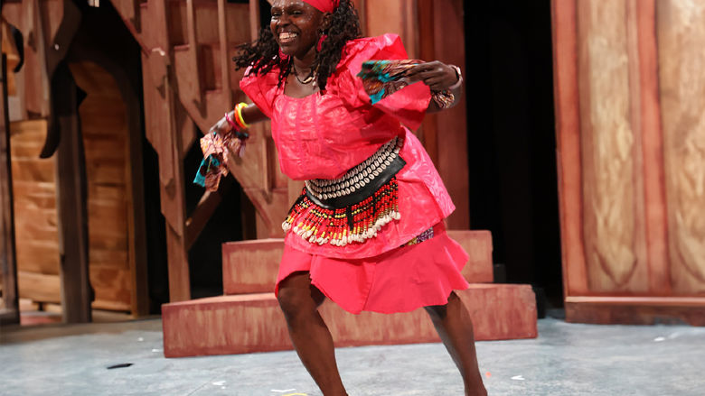 African American woman wearing West African clothing as she dances
