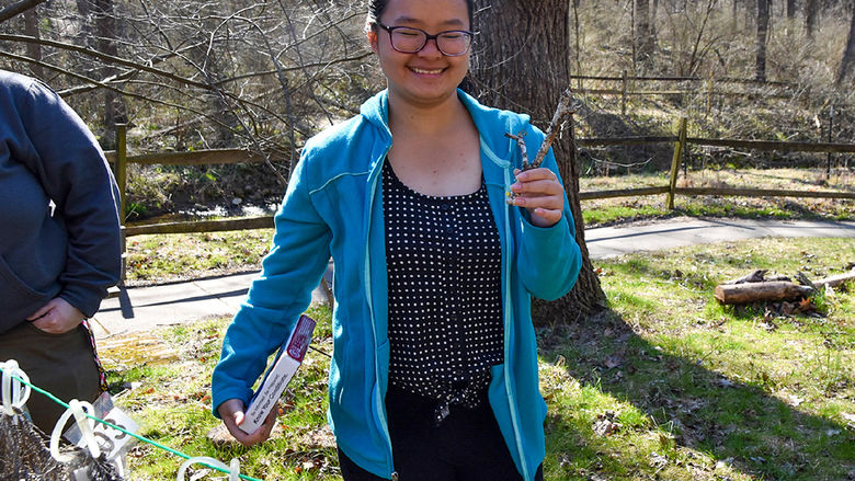 Female Asian student with dark hair and glasses collects specimens in Nixon Park