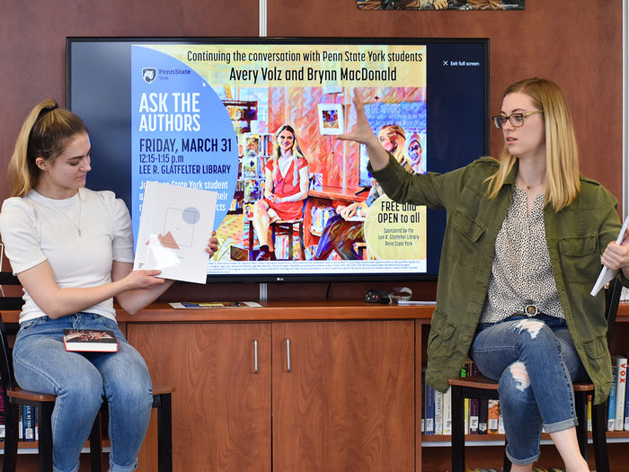 Two student authors, Avery Volz and Brynn MacDonald, presenting their latest work to the campus community.