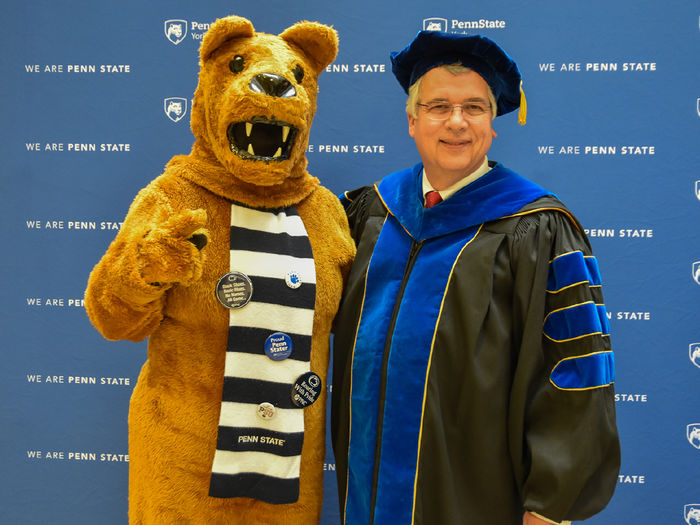 Nittany Lion chracter and adult man wearing commencement regalis