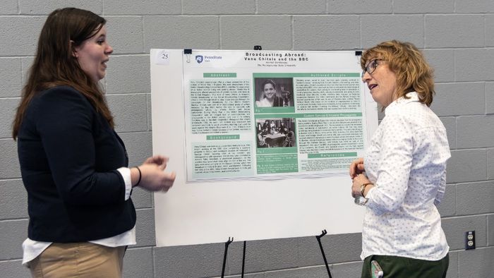 An English student presents her research to a faculty member.