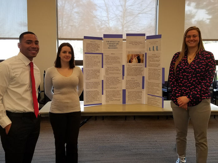 Psychology students presenting their project at a research fair.