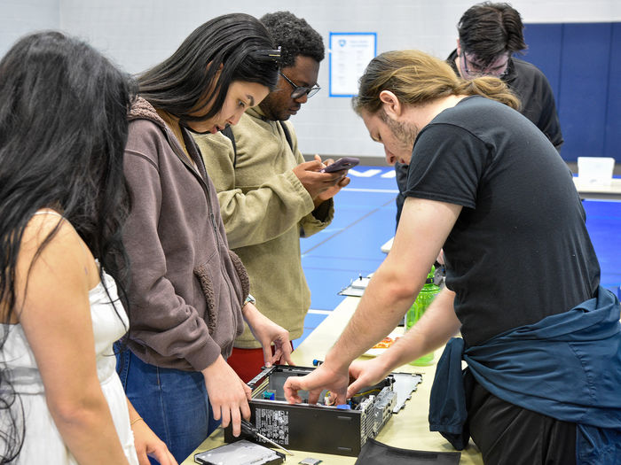 Members of SCROUNGE (Students for Computer Recycling to Outfit Underrepresented Nonprofit Groups in Education) teaching the campus community how to recycle old computer parts.