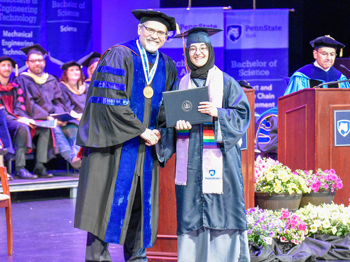 Student receiving her diploma from Chancellor Christiansen.