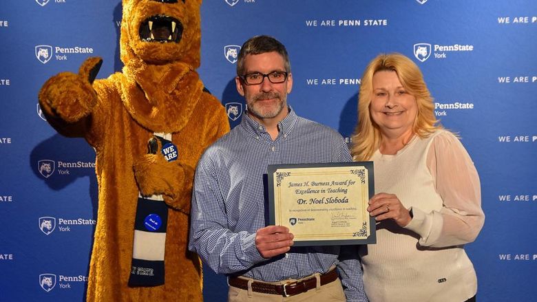Nittany lion Characher with male and female faculty members