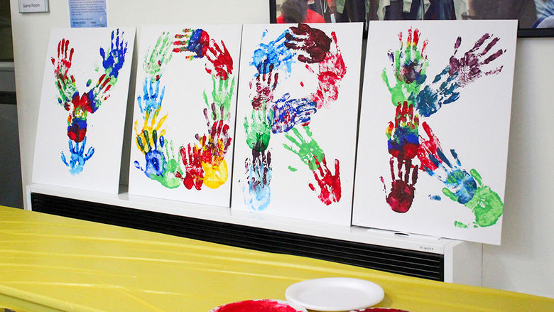 Students and faculty put their printed handprints on white canvases to collectively spell out "We Are Penn State York".