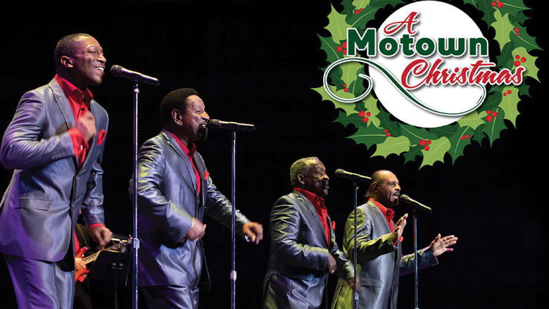 A group of men in suits singing into microphones.