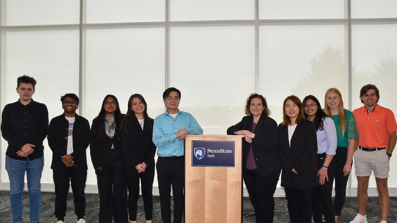 Ten students and faculty memberlined up on either side of a podium