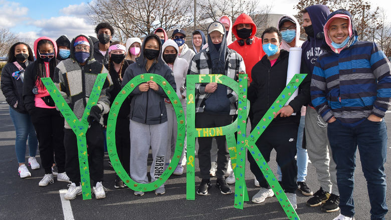 Group of students holding  green wooden letters spelling York 
