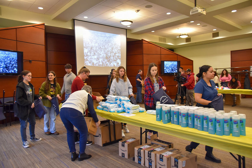 Students, faculty, and staff assembling hygiene kits for the YWCA of York