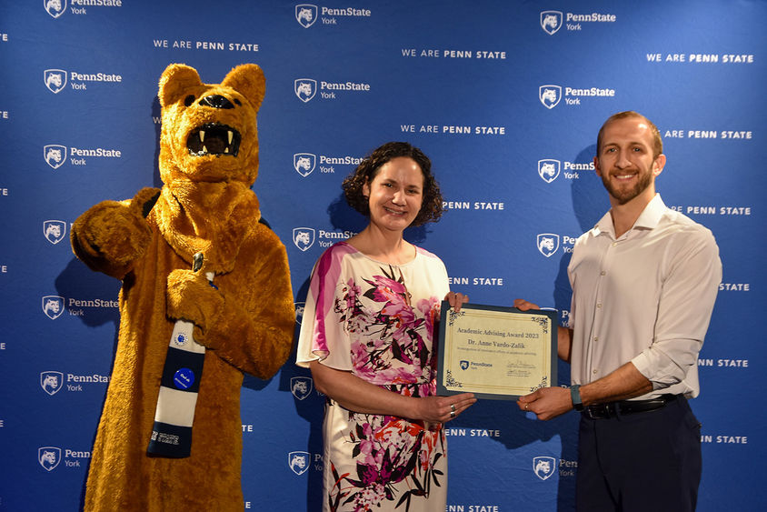 Nittany Lion characters, and a female and male fculty member hold a certificate
