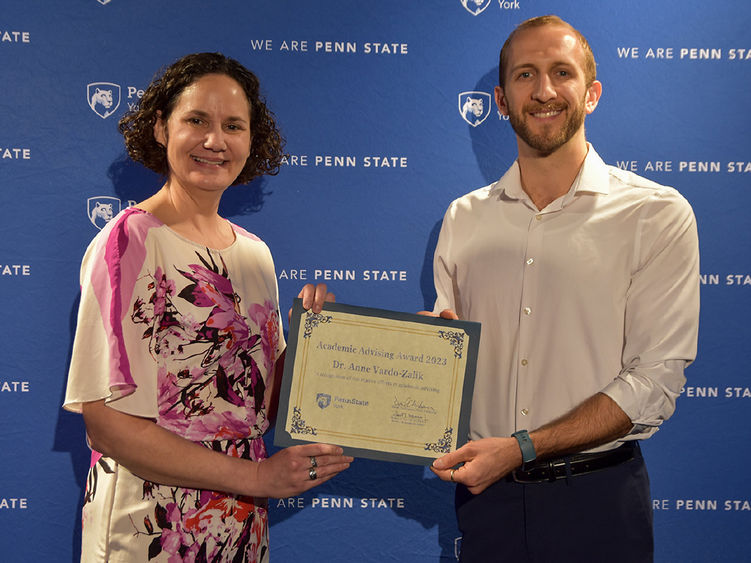 Female with brown hair and male with beard holding a certificate