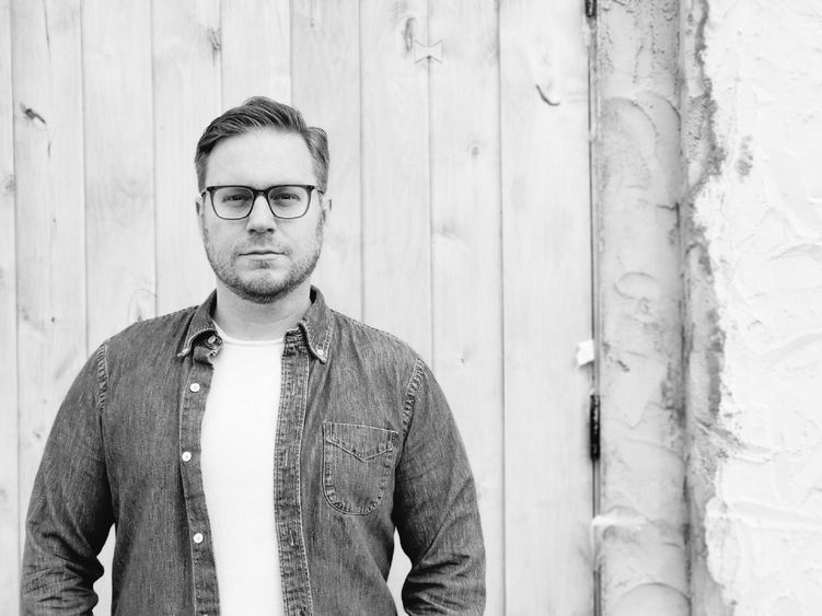 Black and white photo of a person wearing glasses.